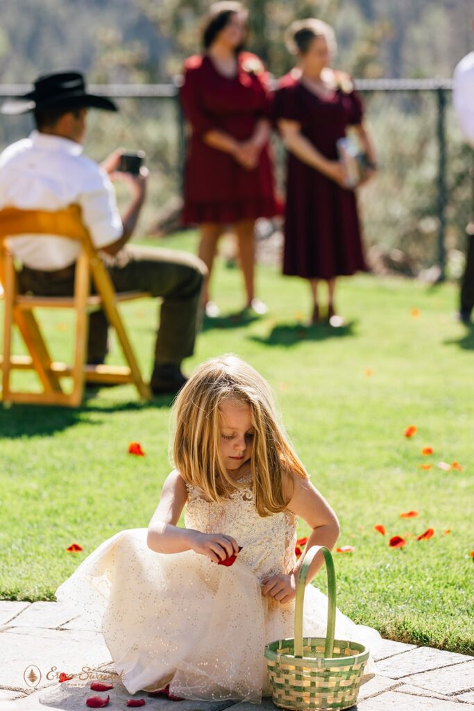 a little flower girl playing with pettals