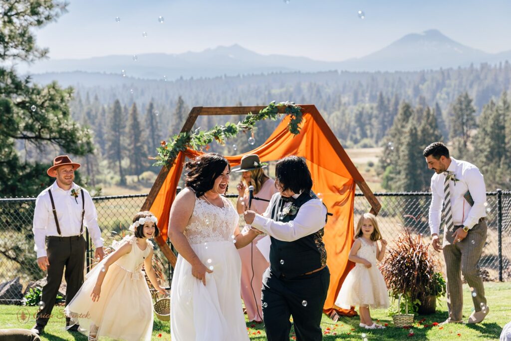 cheerful wedding couple heading off from their outdoor wedding ceremony