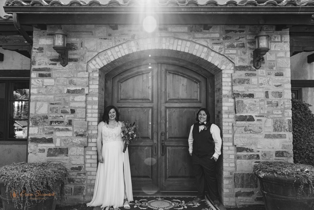 a beautiful lgbtq couple posing by a tuscan style house