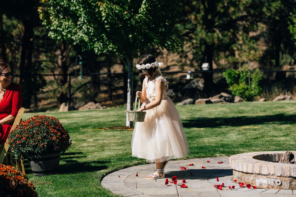 a little flower girl playing with pettals