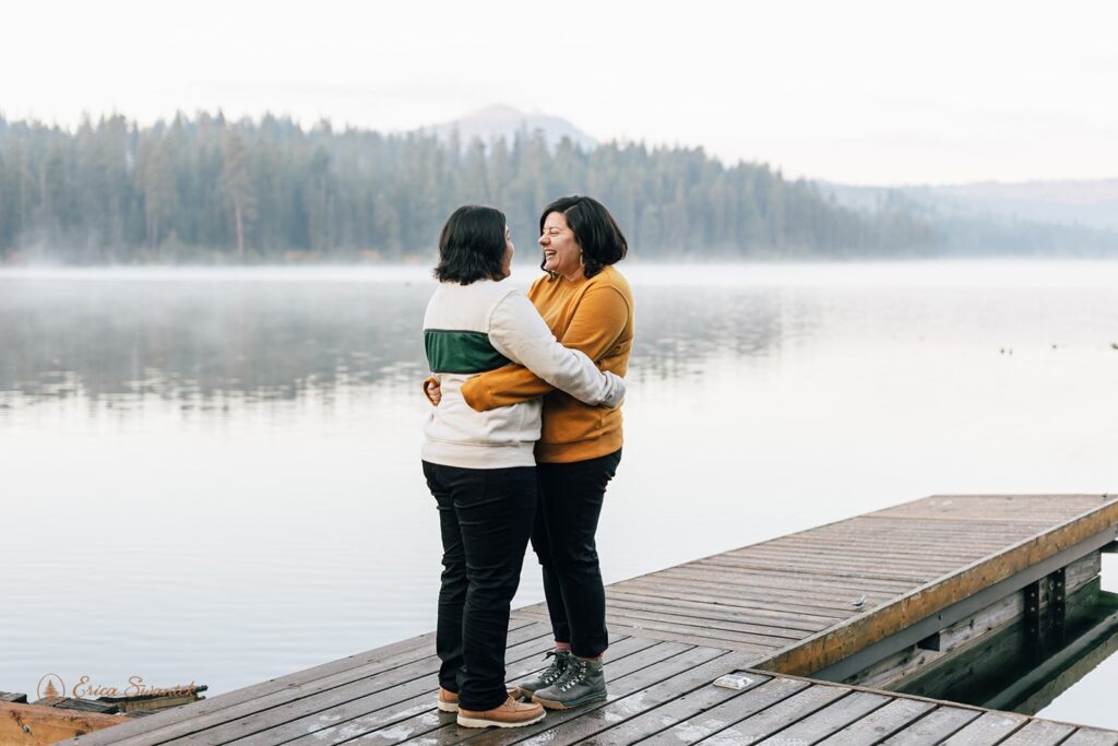 a romantic and playful lgbtq couple hugging by suttle lake at suttle lake lodge