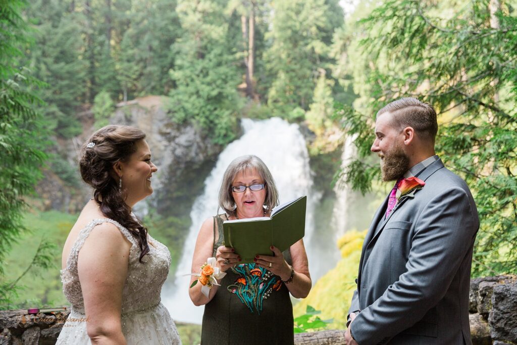 A bride and groom say their wedding vows in front of a beautiful Oregon waterfall. 