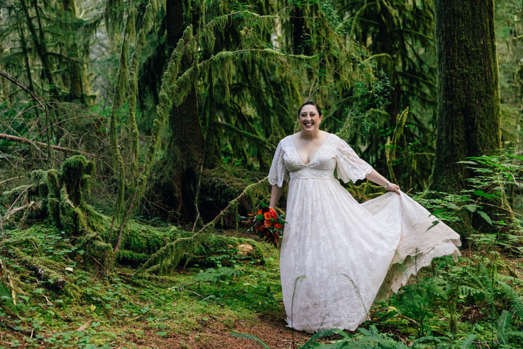 A bride twirls in her wedding dress in the rainforest on the Oregon Coast. 