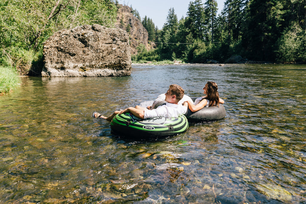 A couple celebrates their Mt. Rainier National Park elopement by jumping in the Naches River. 