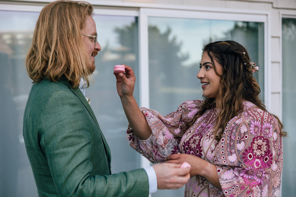 a couple eats macaroons on their elopement day.