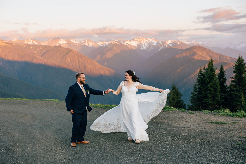 A groom twirls his bride as the alpenglow from the sunset illuminates the Olympic Range on Hurricane Ridge in Washington. 