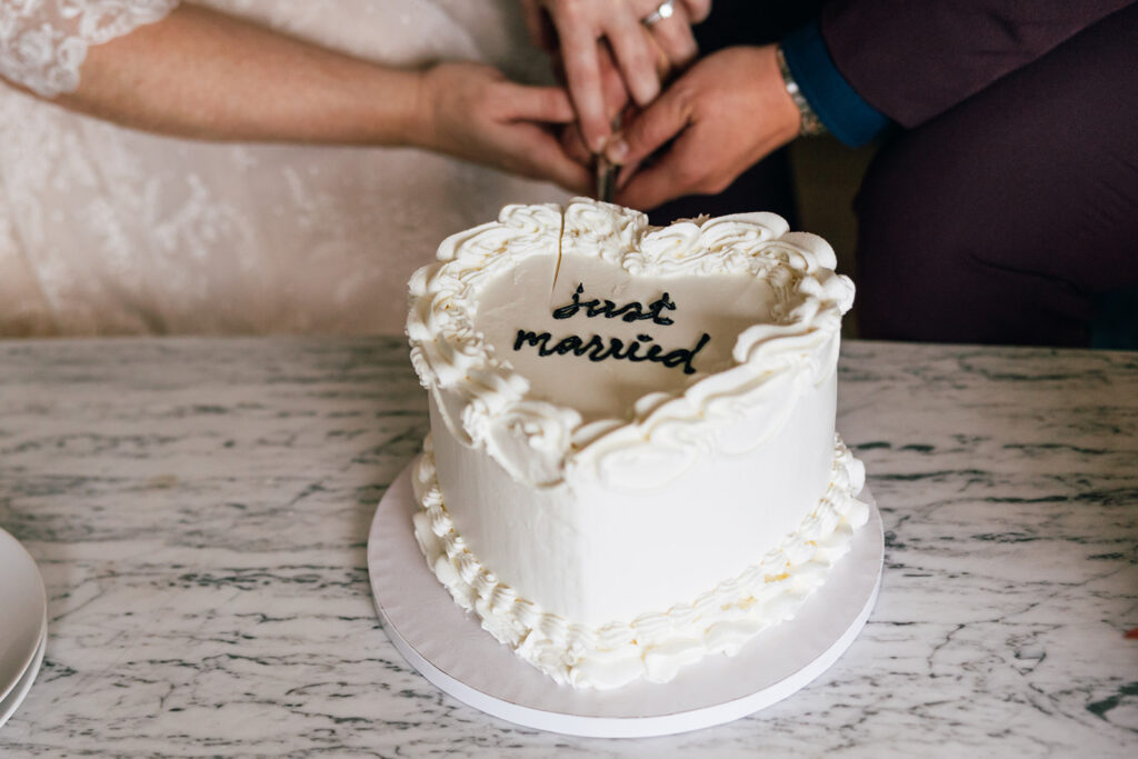 Two brides cut their wedding cake.