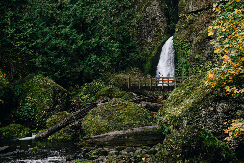 bride and groom hiking to a waterfall on their elopement day