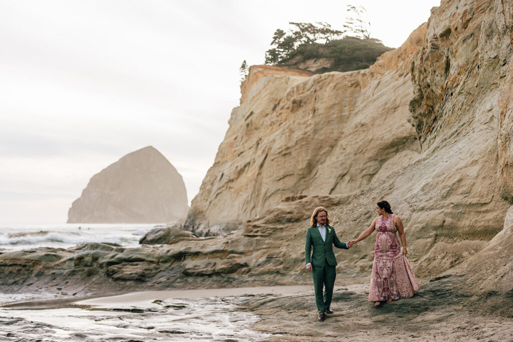 A wedding couple stands by the sandstone bluff of Cape Kiwanda in Pacific City, Oregon. 