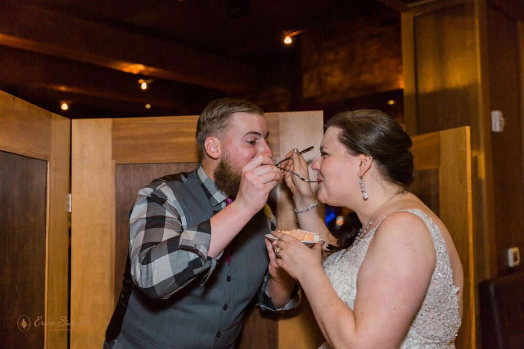 Bride and groom feed each other cake on their elopement day