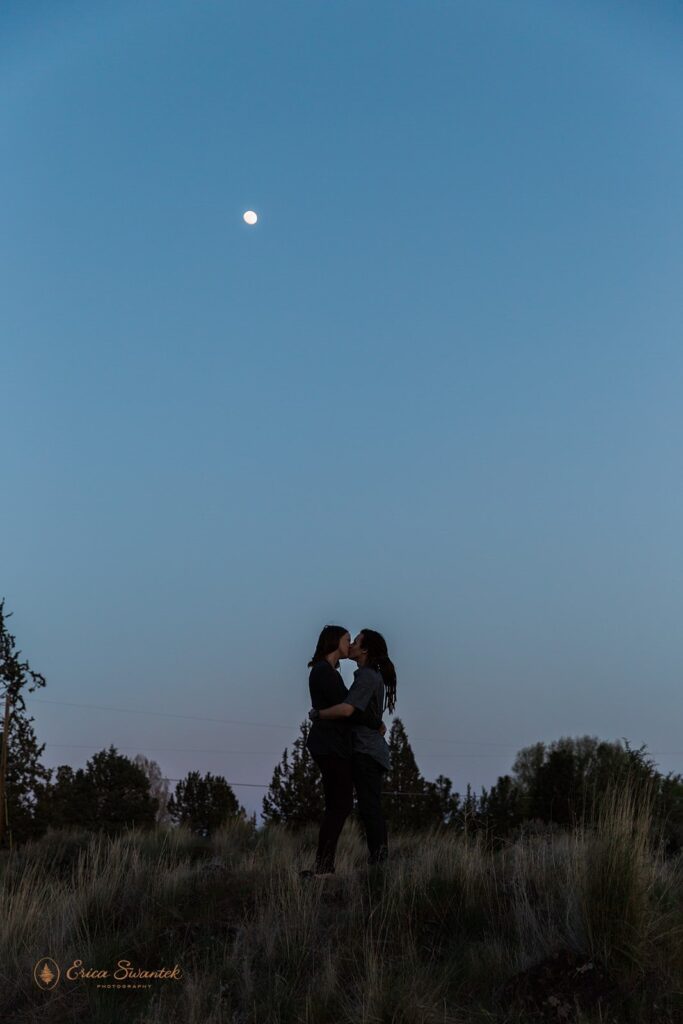 romantic nighttime engagement photo with blue skies and the moon