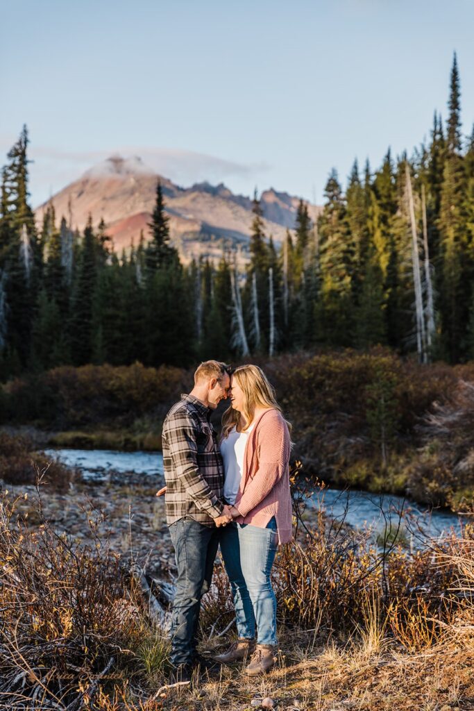 romantic field engagement photos with mountain and forest views in the backdrop in PNW