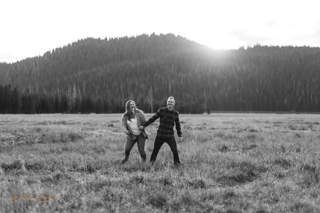 romantic field engagement photos with mountain and forest views in the backdrop in PNW