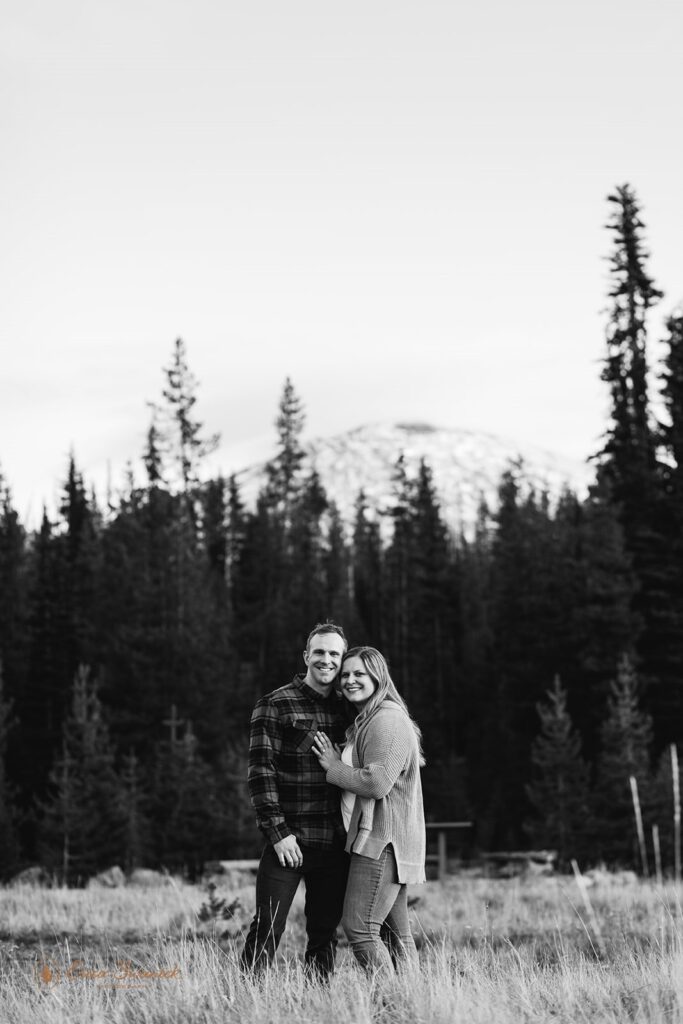 romantic field engagement photos with mountain and forest views in the backdrop in PNW