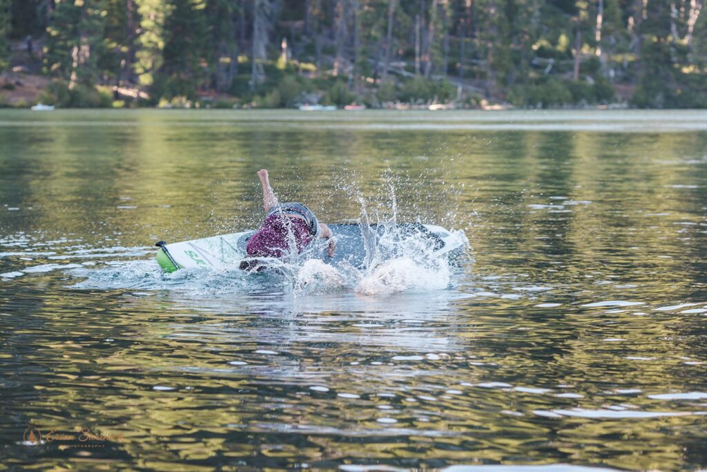 fun couple paddleboarding on a lake for their engagement session