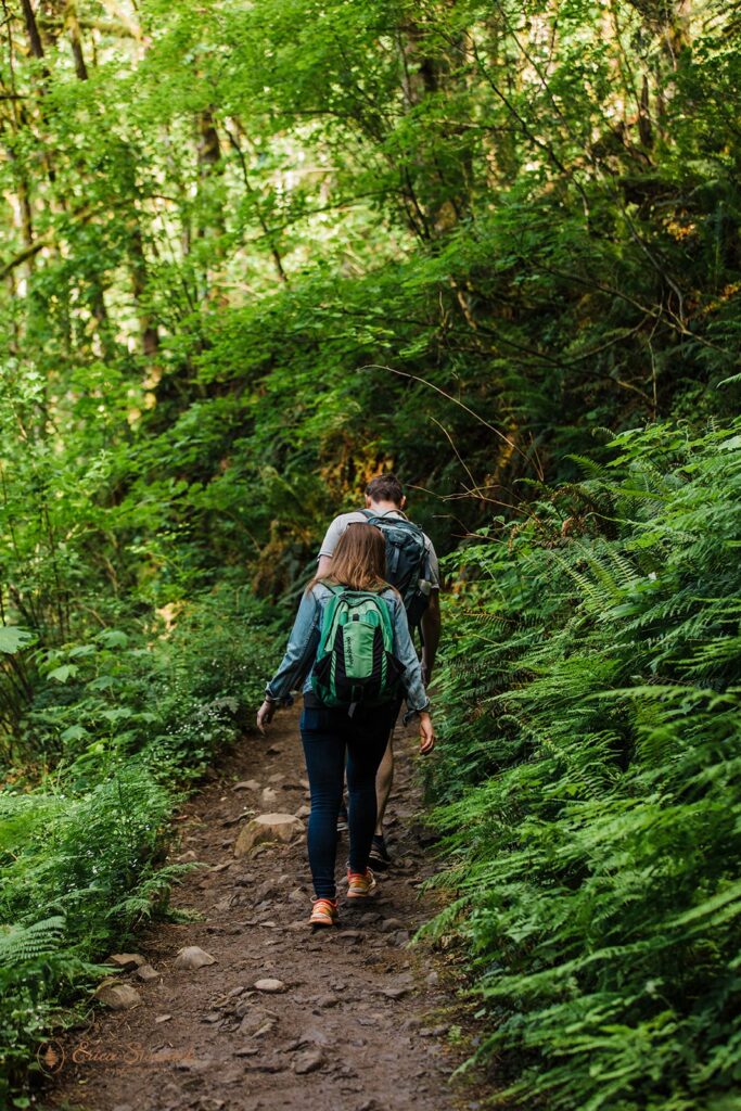 fun couple going on a hike through a lush forest in PNW