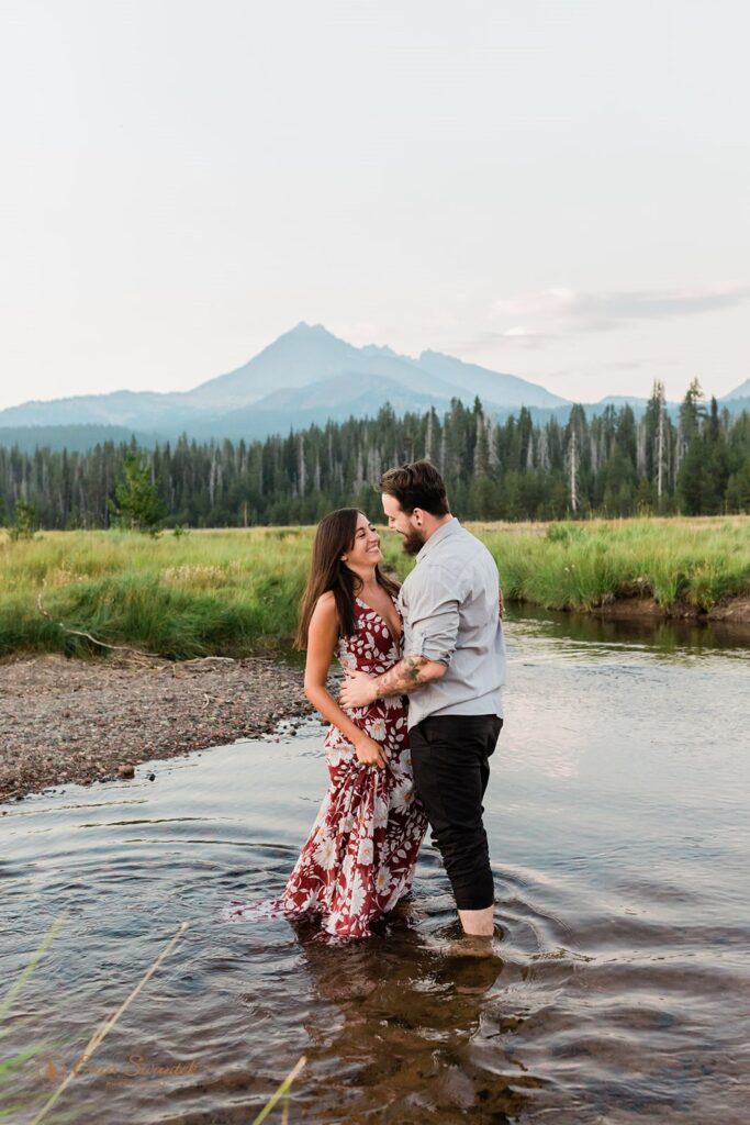 couple walking through a shallow water stream and being playful with each other