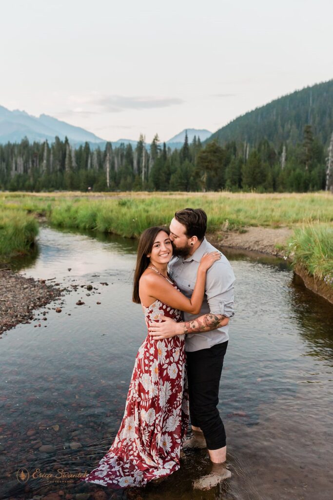 couple walking through a shallow water stream and being playful with each other