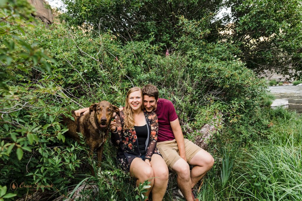 lovely engaged couple sitting together with their dog