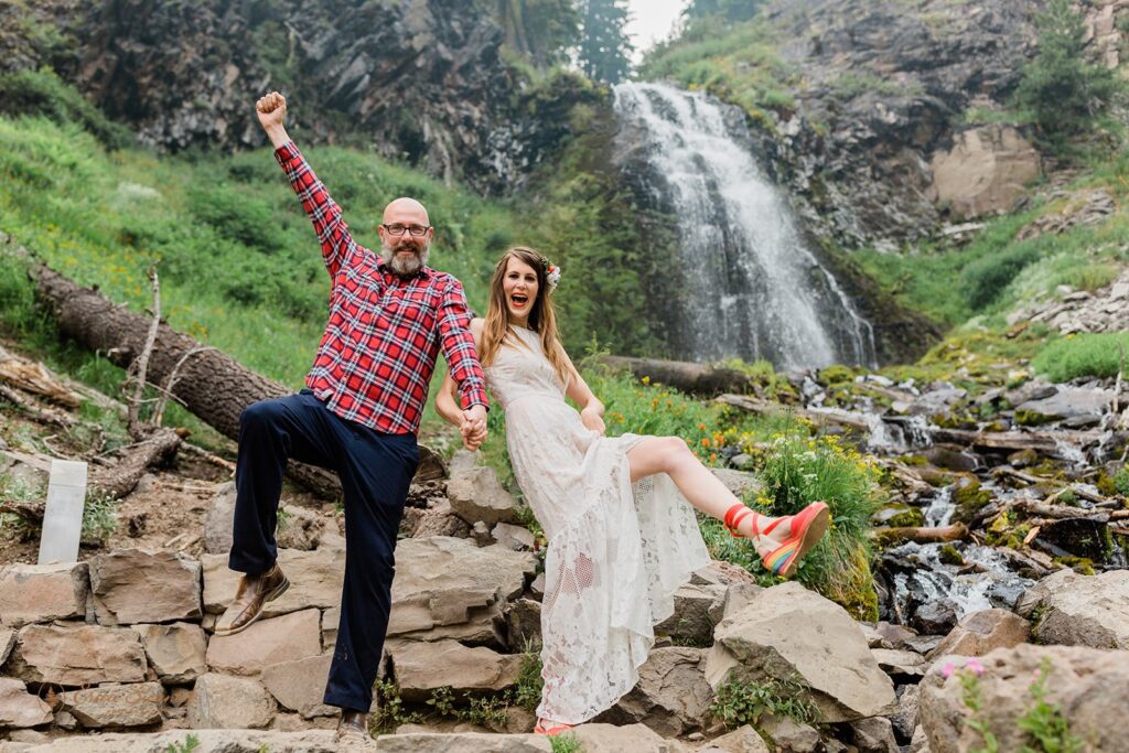 excited newly weds celebrating their elopement with beautiful waterfall backdrops