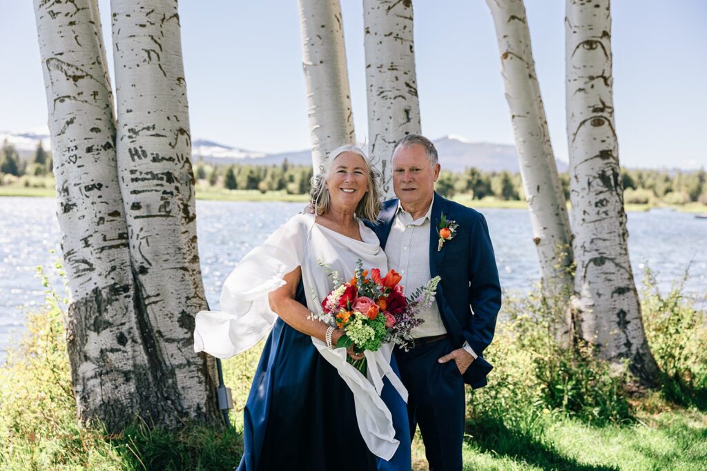 candid and playful elopement couple with wind messing with their attire and hair