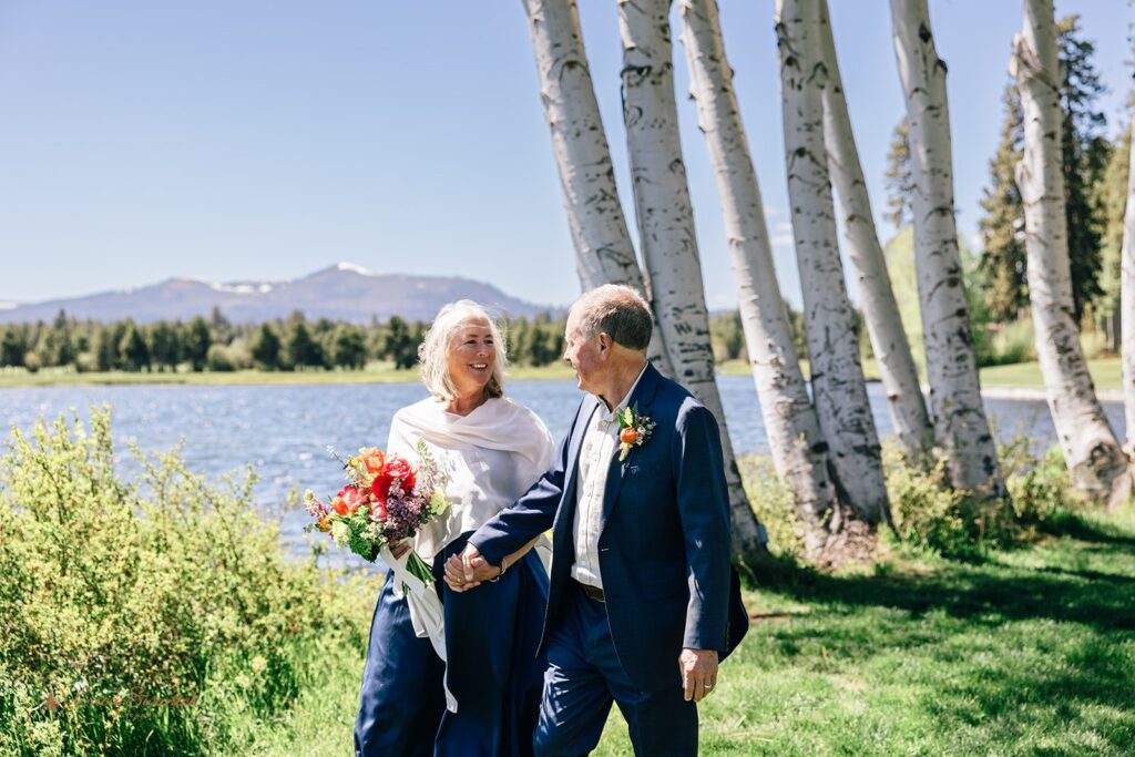 candid and playful elopement couple with wind messing with their attire and hair