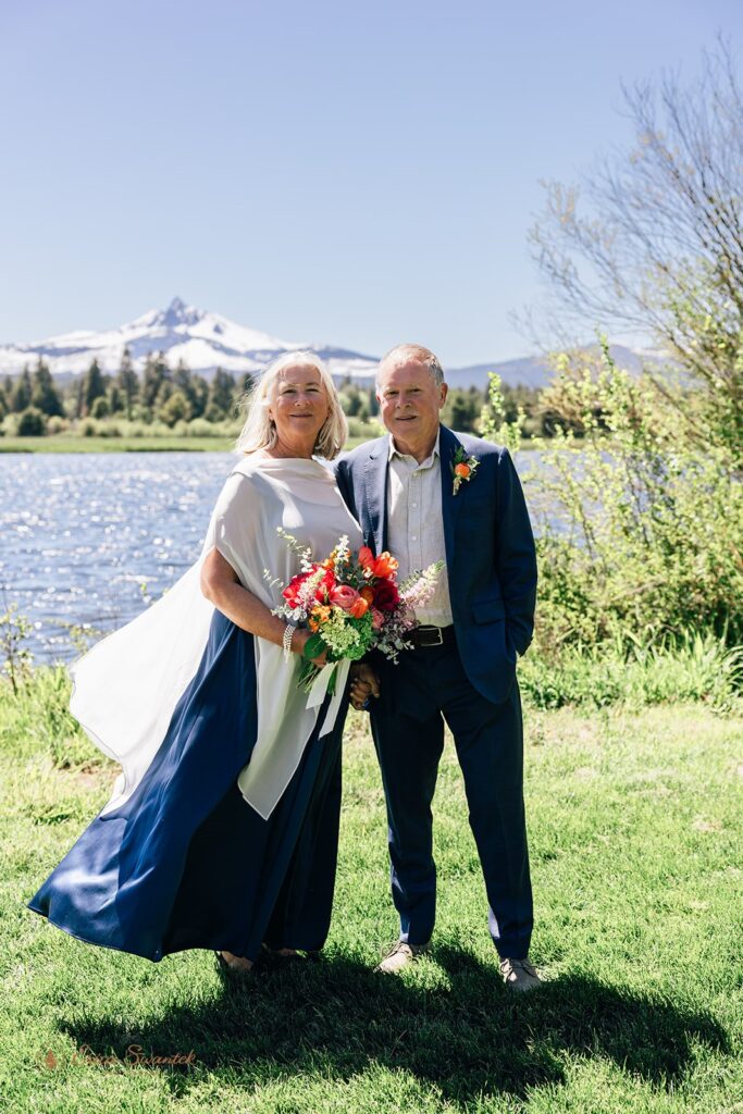 candid and playful elopement couple with wind messing with their attire and hair