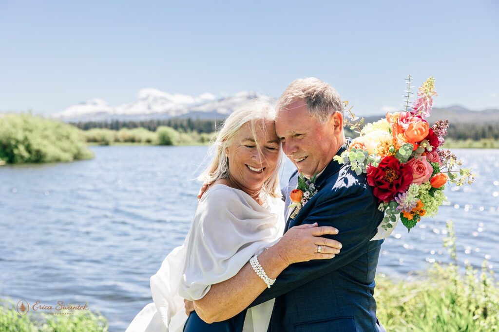 candid and playful elopement couple with wind messing with their attire and hair