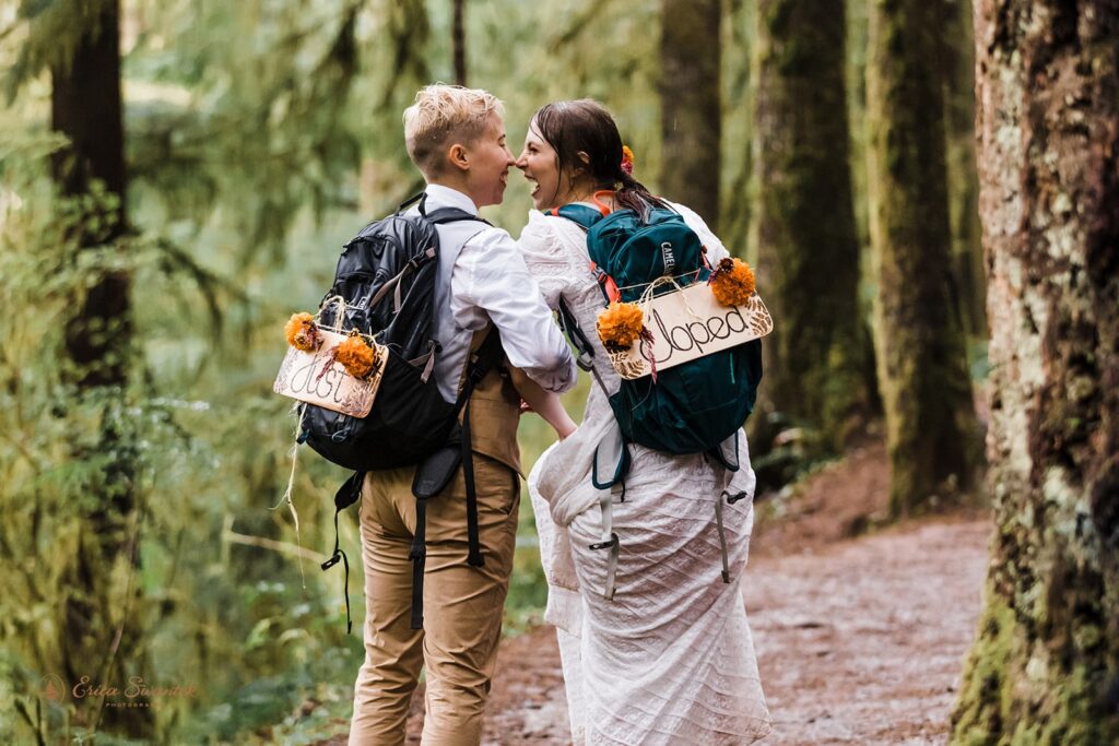 newly weds soaking wet during their rainy PNW elopement while hiking through the forest