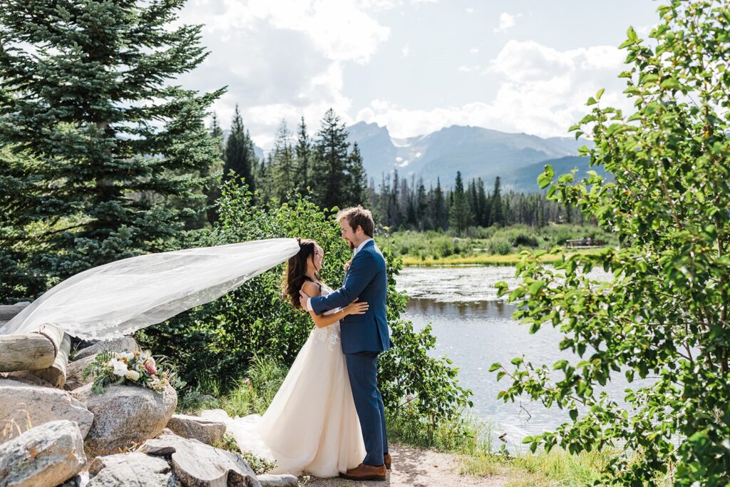 candid and playful elopement couple with wind messing with their attire and hair