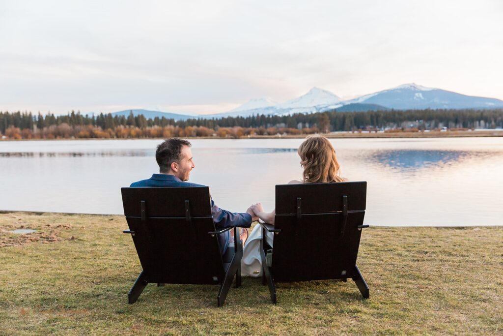 dreamy elopement couple sitting by a gorgeous lake with mountain views at Black Butte Ranch