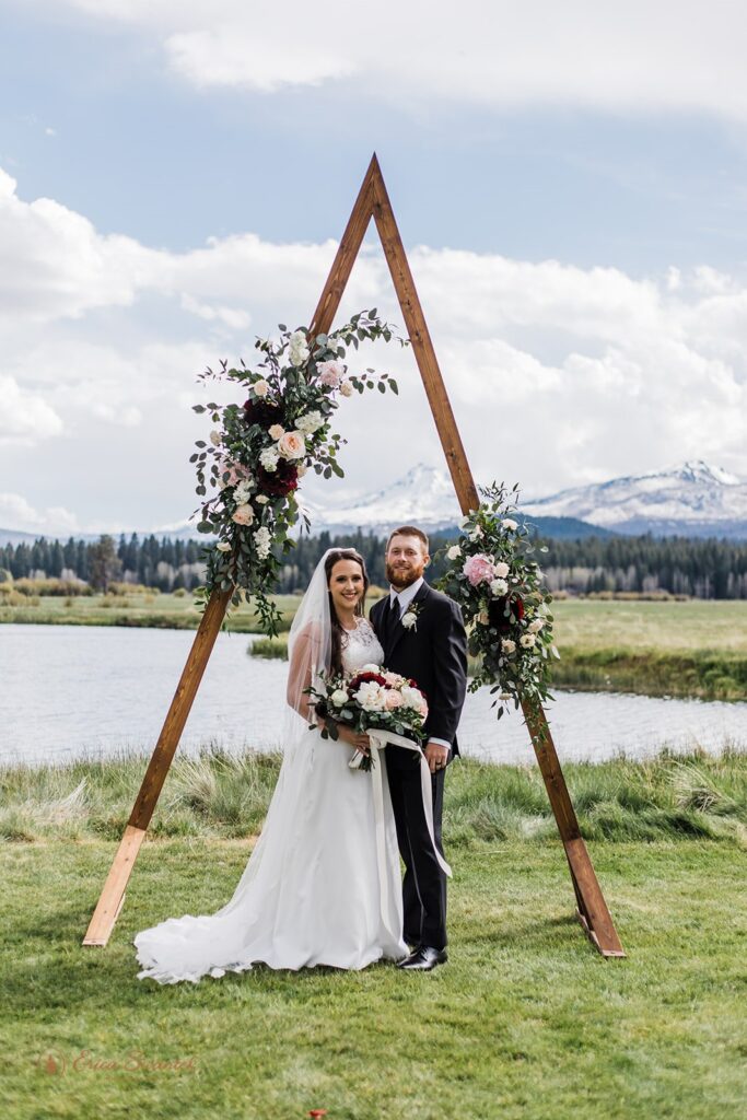 bride and groom posing at their A frame arch during their PNW elopement in Bend, Oregon