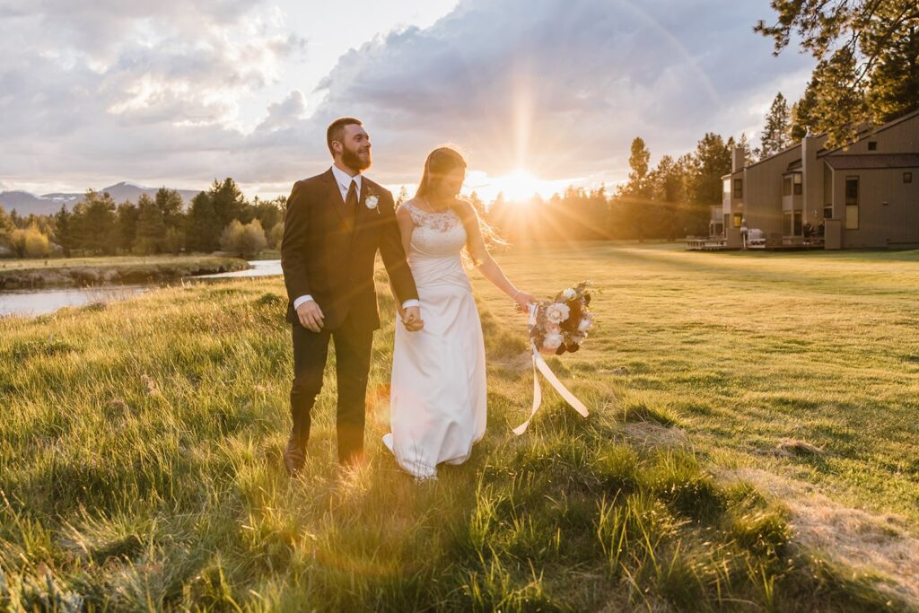 bride and groom roaming around a lush field during golden hour in Oregon