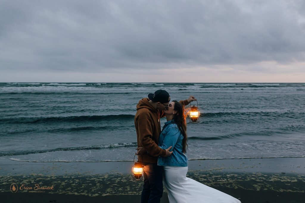 a moody oregon coast elopement, couple roaming the coastline with lanterns