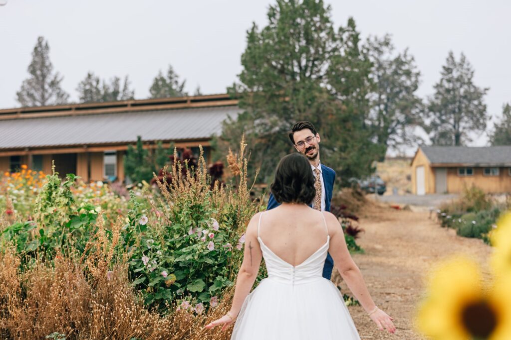 wedding first look surrounded by colorful flowers