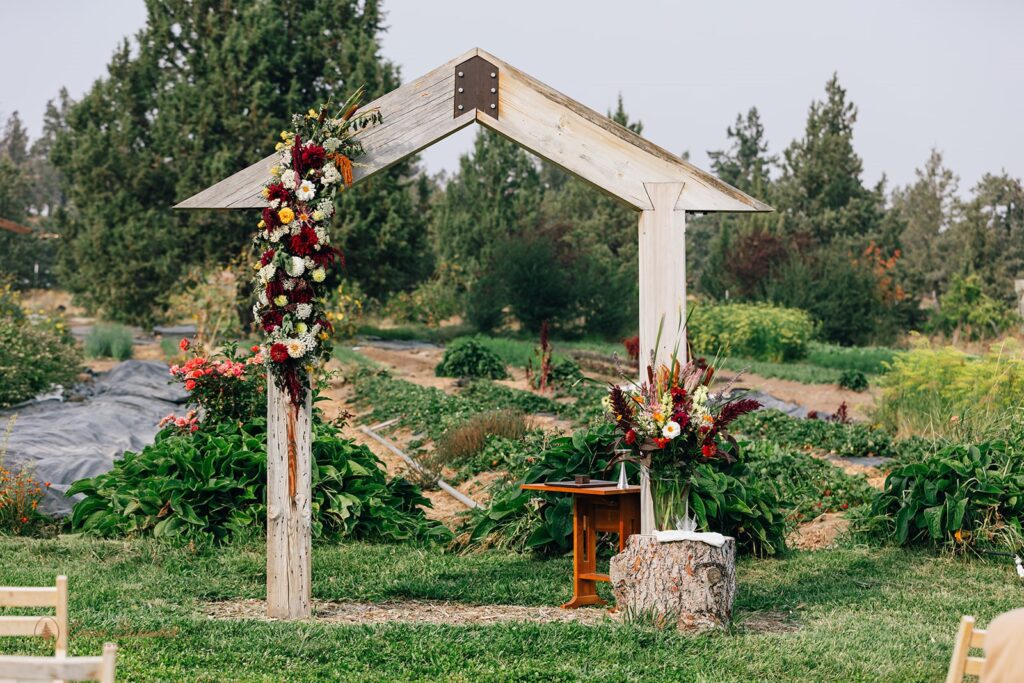 a wooden wedding arch decorated with colorful florals