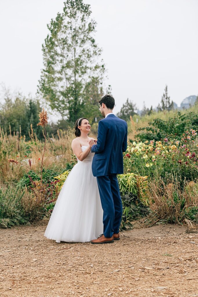 wedding first look surrounded by colorful flowers