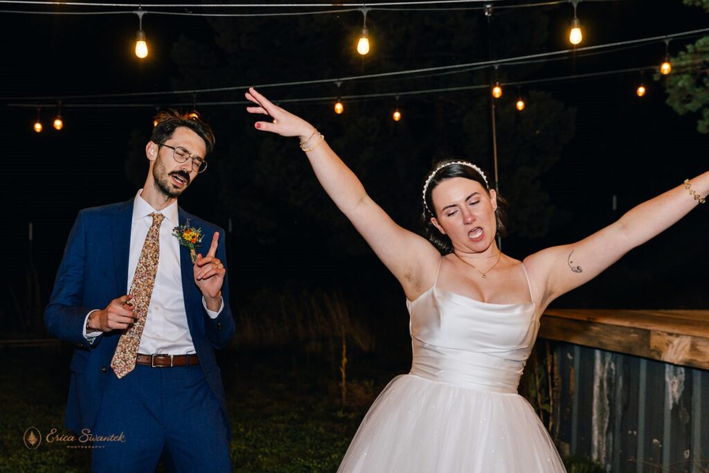 The bride and groom dance with playful expressions during their wedding reception