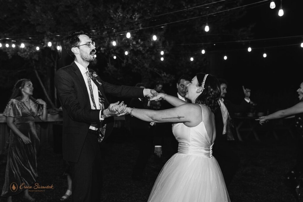 The bride and groom dance with playful expressions during their wedding reception