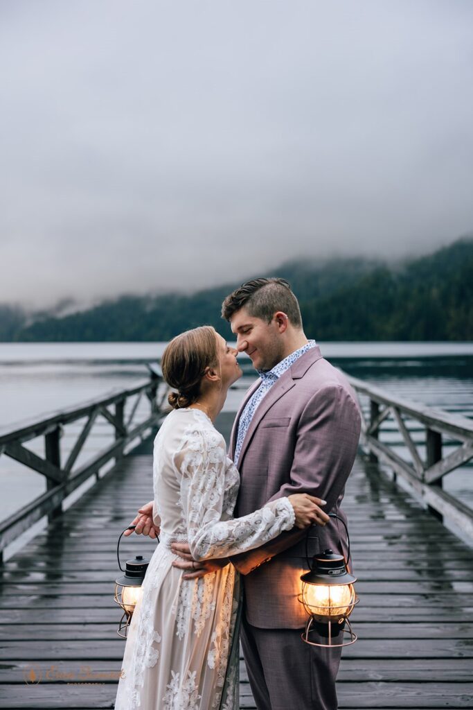 dreamy elopement couple standing with lanterns in hands before sunrise