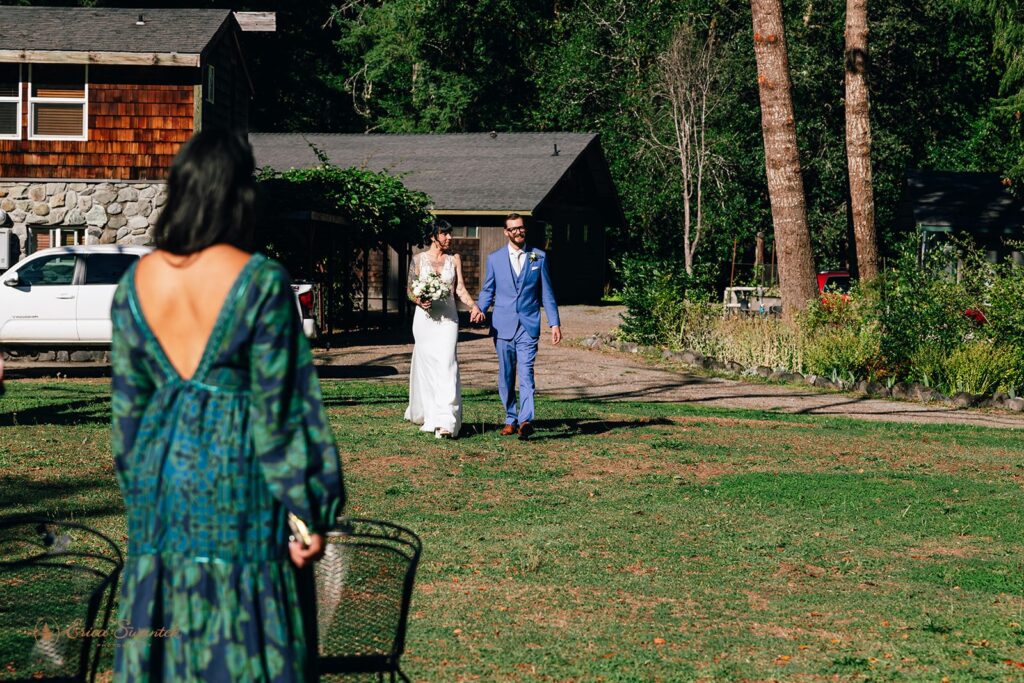 bride and groom walking hand in hand towards their chetco river elopement ceremony location