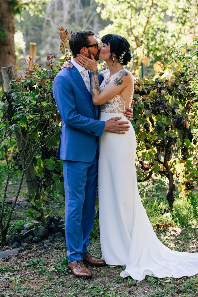 bride and groom kissing surrounded by lush greenery during their chetco river elopement