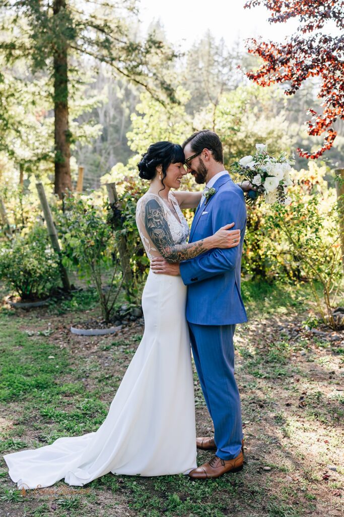 bride and groom kissing surrounded by lush greenery during their chetco river elopement