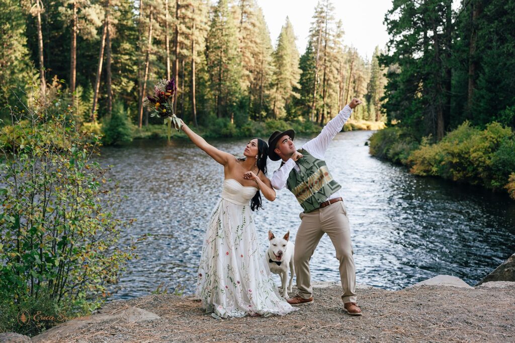 fun elopement couple dabbing by a river with their dog in between