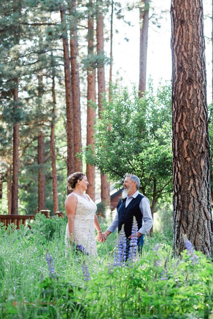 bride and groom in a lush field with cute flowers