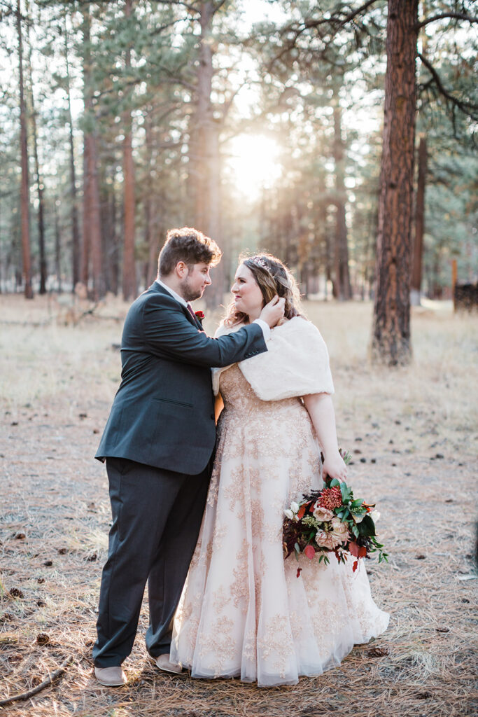 elopement couple walking through a forest together with sun shining through the tree tops