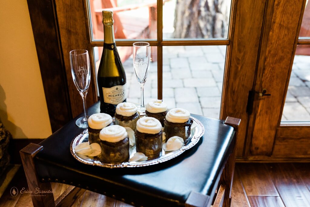 cute wedding cupcakes with white frosting and a bottle of bubbly with two champagne flutes