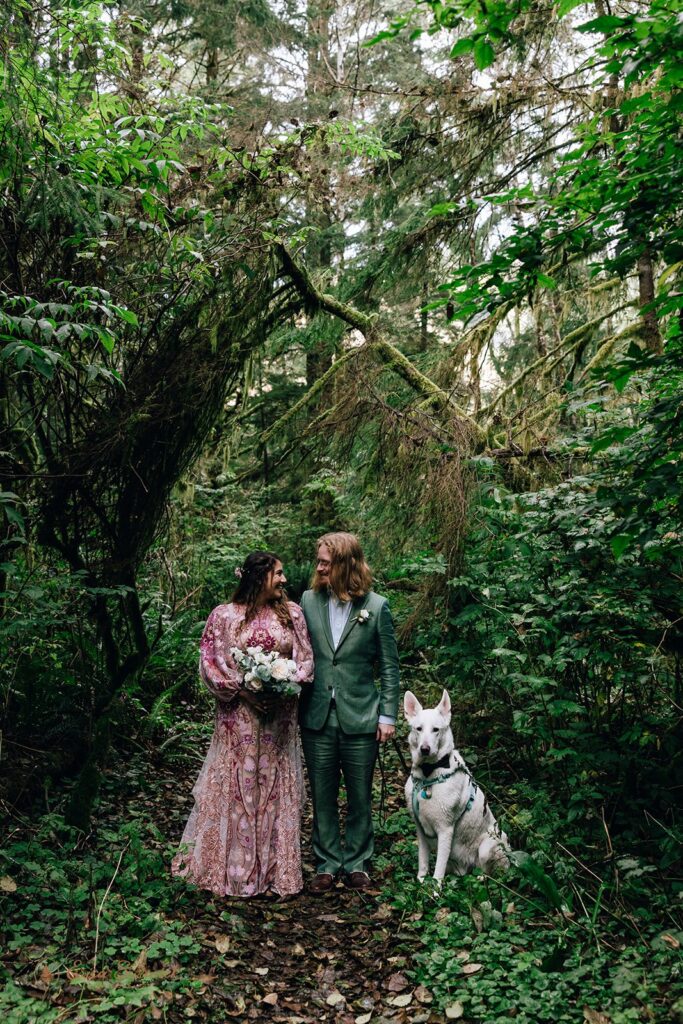 bride and groom and their dog at the rainforest trail surrounded by lush greenery