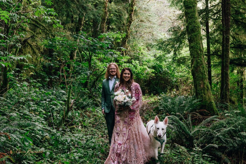 bride and groom and their dog at the rainforest trail surrounded by lush greenery