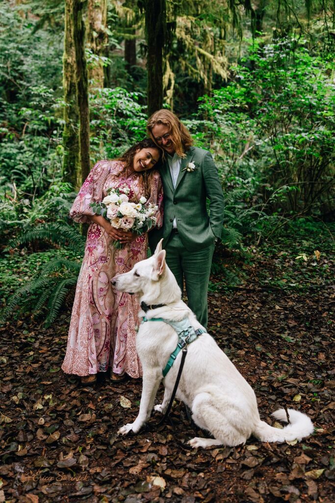 bride and groom and their dog at the rainforest trail surrounded by lush greenery